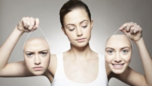 Young woman holding emotive masks